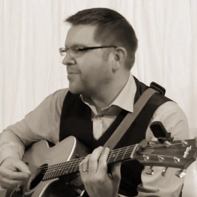 An image of Mick, the Lux Bay acoustic duo guitarist, playing live music at a wedding breakfast. 
