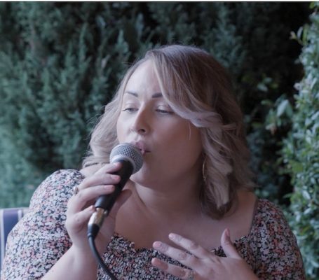 An image of Becci, the Lux Bay acoustic duo singer, playing live at a wedding breakfast. 