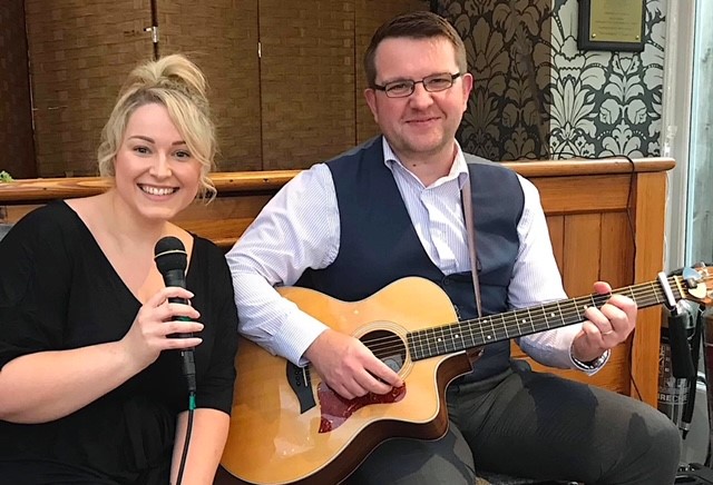 An image of Lux Bay acoustic duo playing live at a Christening.