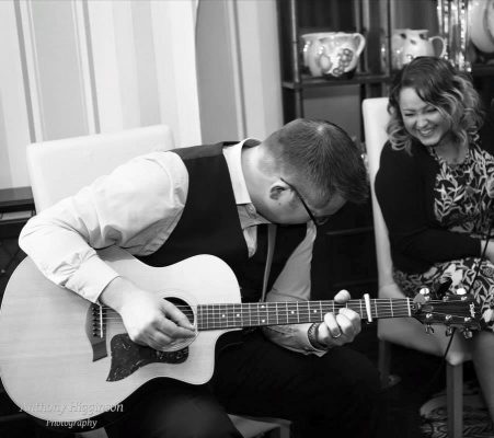 An image of Lux Bay acoustic duo playing live music.